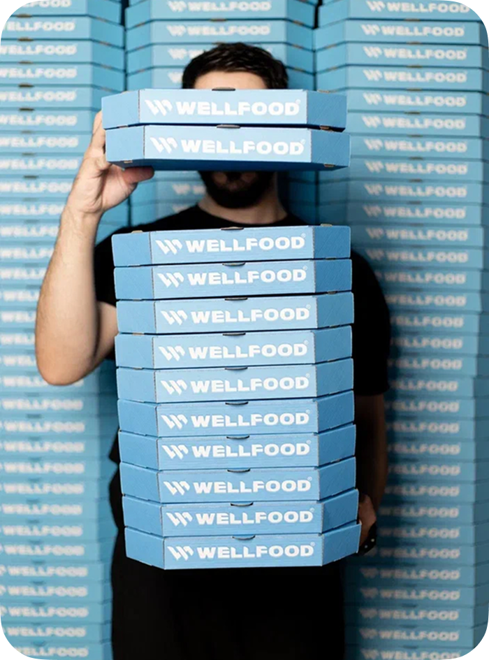 Курьер Wellfood с коробками заказов